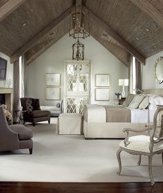 a large bedroom with white carpeting and wooden beams on the ceiling is decorated in neutral colors