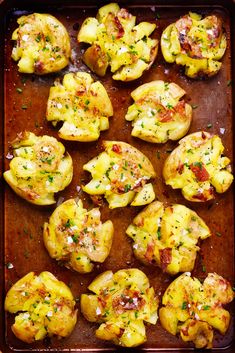 baked potatoes with cheese and herbs on a baking sheet