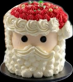 a santa clause cake with white frosting and red flowers on it's head