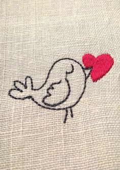 a small embroidered bird with a heart on it's back