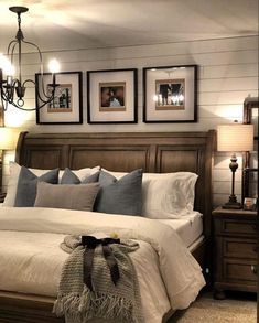 a large bed sitting in a bedroom next to two lamps and pictures on the wall