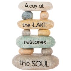 a stack of rocks with words on them that read, a day at the lake restores the soul