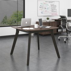 an office with two desks and one laptop on the table in front of a window