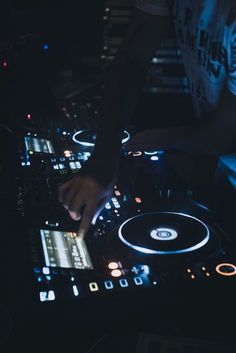 a dj mixing music on his turntable in the dark