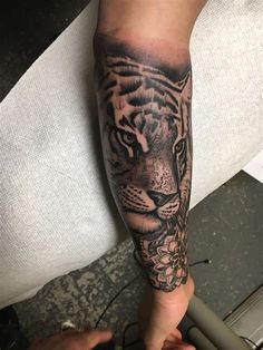 a man with a tiger tattoo on his arm