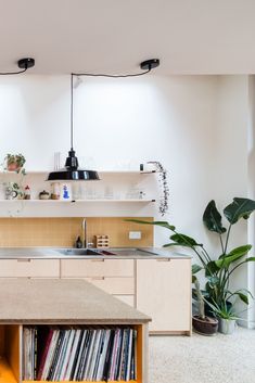 a kitchen with an island in the middle and lots of records on the counter top