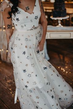 a woman in a white dress standing on a wooden floor