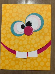 a yellow paper bag with a red nose and big eyes on the inside, cut out to look like a face