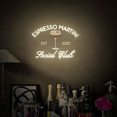 a neon sign that reads espresso martini social club next to bottles of liquor