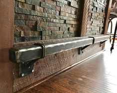 a metal handle on the side of a brick wall next to a wooden floor and bar stools