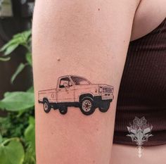 a woman's arm with a tattoo of a pickup truck