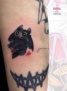 a black cat with green eyes and fangs on its face is depicted in this tattoo design