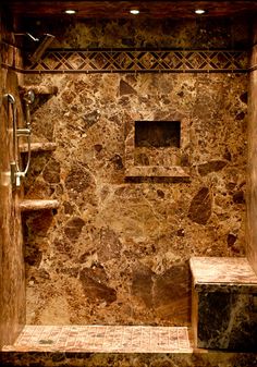 a walk in shower sitting next to a stone wall