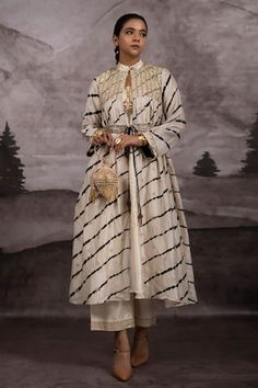 Ivory shrug dress featuring full sleeves, band collar, and gathered flare design. Paired with a sleeveless embroidered inner kurta, matching palazzo pant, and a hand embroidered belt., Fit: Relaxed Lehriya Kurti Designs, Leheriya Dress, Tie Dye Embroidery, Shrug Dress, Ikat Motifs, Bandhej Suits, Saree Reuse, Bandhani Dress, Shrug For Dresses