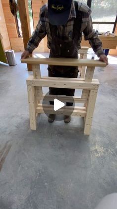 a man standing in front of a chair made out of wooden planks and plywood