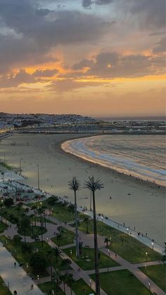 an aerial view of the beach and ocean at sunset