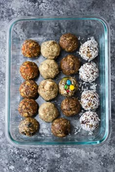 a glass container filled with lots of different types of balls and toppings on top of a table