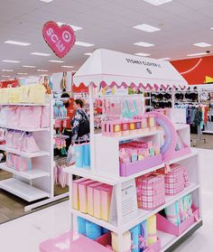 a store filled with lots of pink and yellow items next to shelves full of baby goods