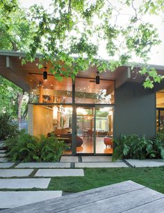 a modern house with glass walls and trees