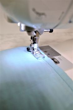 the sewing machine is working on the piece of fabric that has been sewn together