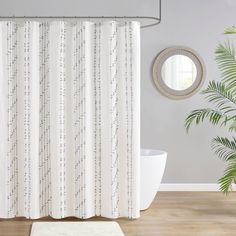 a bathroom with a shower curtain, rug and potted plant