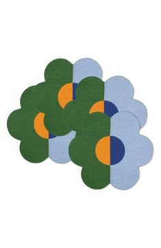 four pieces of blue and green paper with circles on the top, one has an orange center