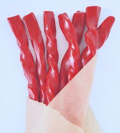 red candy sticks sticking out of a brown paper bag