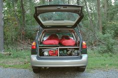 the back end of a car with its trunk open and luggage in it's cargo compartment