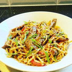 a white bowl filled with noodles and vegetables