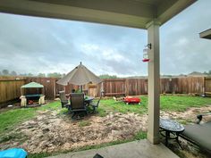 a backyard with lawn chairs and an umbrella