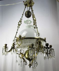 a chandelier hanging from the ceiling in a room with white walls and curtains