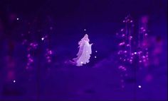 a woman in a white dress is flying through the air with purple lights behind her