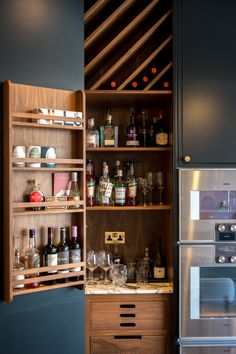 an open cabinet with bottles and glasses on it