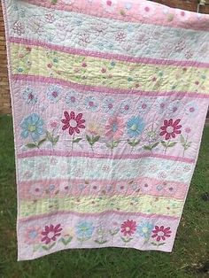 a pink and blue quilt hanging from a clothes line