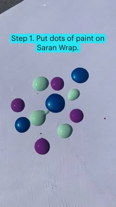 several balls are scattered on the ground with text overlay that reads, step 1 put dots of paint on sarn wrap