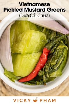 vietnamese pickled mustard greens in a white bowl with red peppers