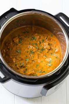 an overhead view of a slow cooker filled with stew and garnished with parsley