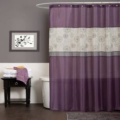 a bathroom with a purple shower curtain and white toilet in the corner next to a bath tub