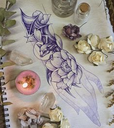 a table topped with lots of different types of flowers and plants next to a candle