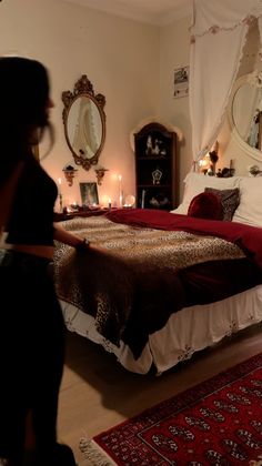 a woman standing in front of a large bed