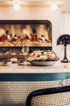 a table with food and wine glasses on it in front of a display case filled with seafood