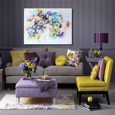 a living room filled with purple and yellow furniture next to a painting on the wall