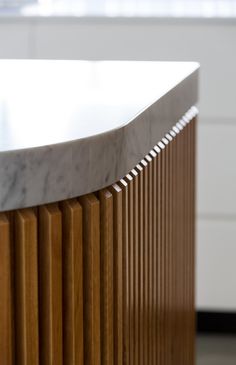 a marble counter top sitting on top of a wooden cabinet next to a white wall