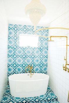 a bathroom with blue and white tiles on the walls, an oval bathtub in the middle