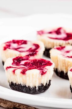 mini cheesecakes with raspberry filling on a white plate, ready to be eaten