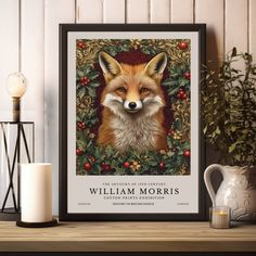 a framed print of a red fox surrounded by holly and berries with the words william morris on it