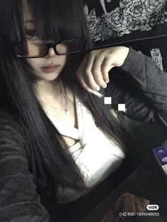 a woman with long black hair wearing glasses