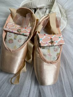 two pairs of ballet shoes with bows on them