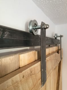 a close up of a metal handle on a wooden door with some wood planks