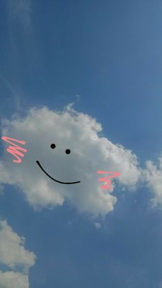 a smiley face drawn on the side of a cloudy blue sky with clouds in the background